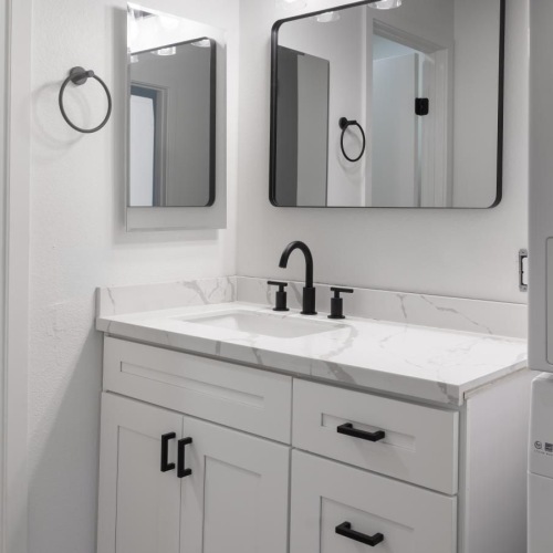 a bathroom with white cabinets