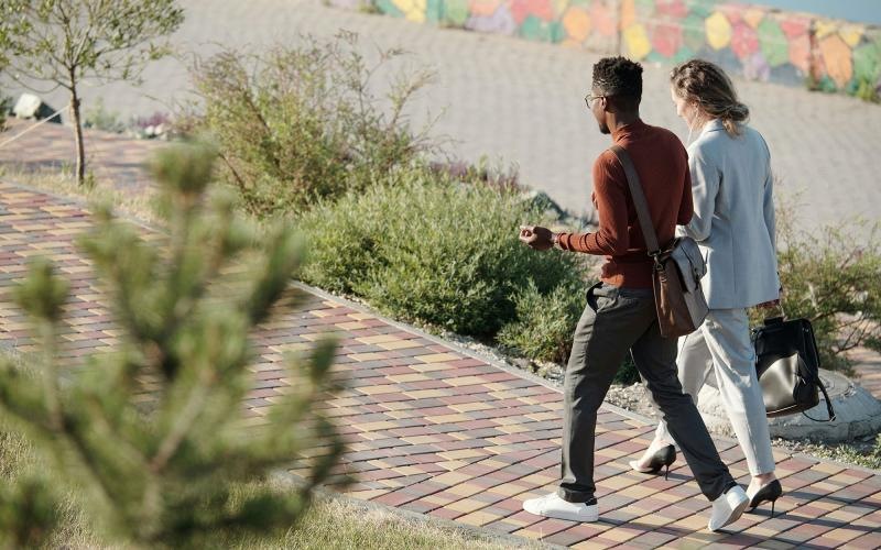 A man and woman walking on a brick sidewalk