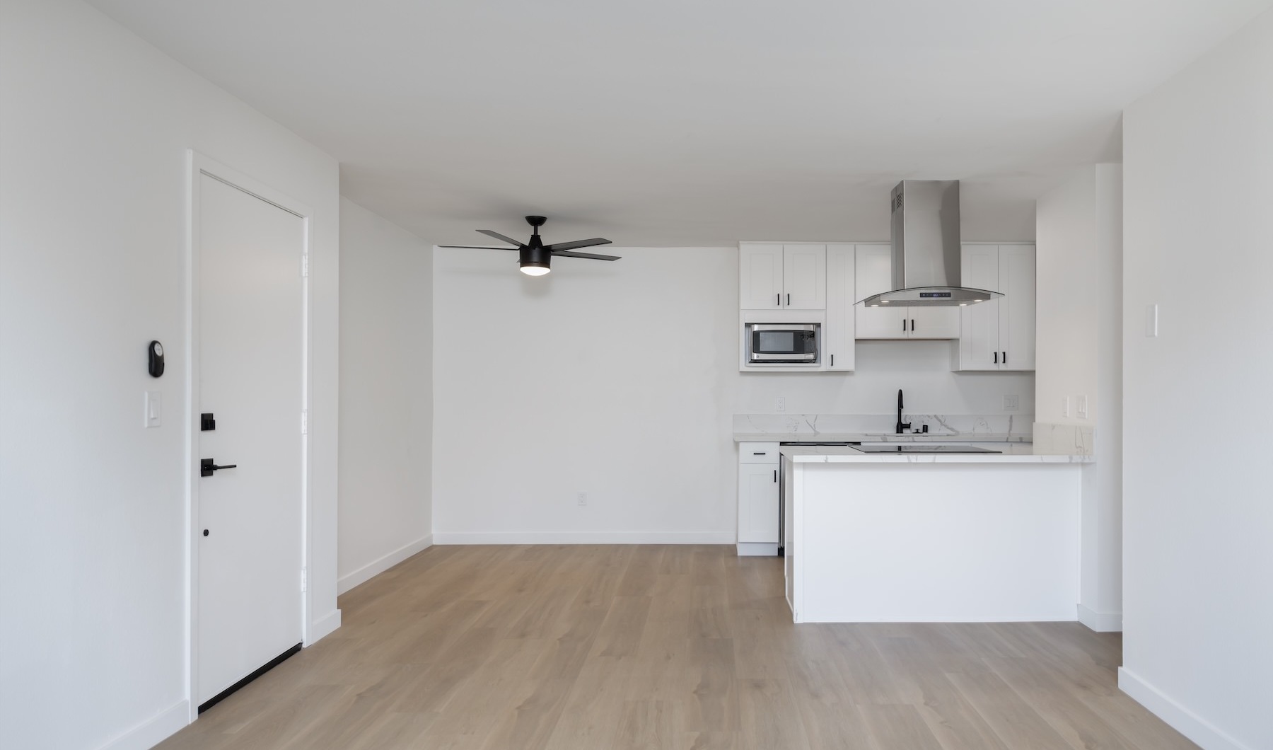 a living room with white walls and wood floors