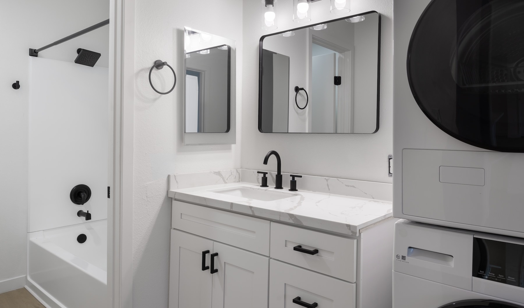 a bathroom with a shower, sink and washer and dryer